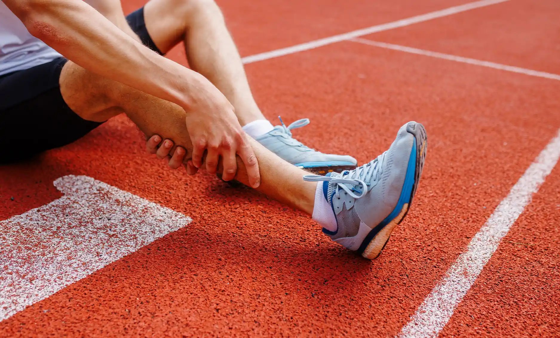Athlete experiencing ankle discomfort on a track; seek care for effective diagnosis and treatment at Foot & Ankle Center of Arizona.